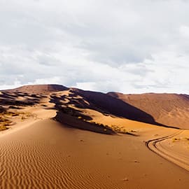 库布齐沙漠是中国第七大沙漠，蒙古语“库布其”的意思是弓上的弦，因为它处在黄河下像一根挂在黄河上的弦，因此得名。因属于沙漠气候区，最佳的旅游时间在每年的5、6、9、10月。库布齐沙漠景观壮美，风光独特，尤其是响沙湾景区以浩瀚的特大响沙带堪称天下一绝，在干燥条件下，沙子只要受到外界触动就会发出一种像飞机越顶而过的“嗡嗡嗡”的轰鸣声，四季皆响，十分奇妙。